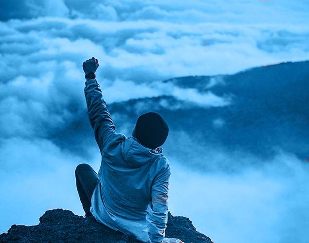 man at the top of a mountain
