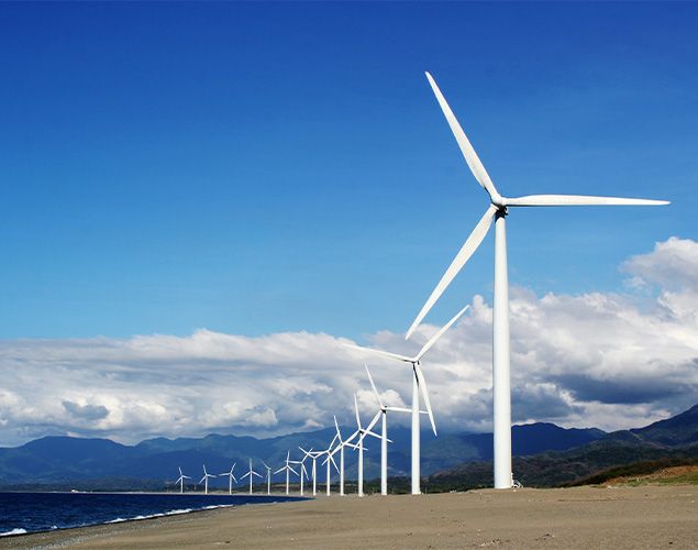 White Wind Turbines on Gray Sand Near Body of Water