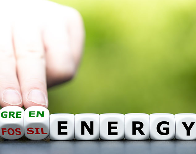 Hand turns dice and changes the expression `fossil energy` to `green energy`